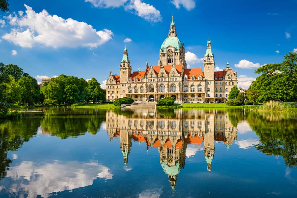 Ein reich verziertes Gebäude spiegelt sich in einem Teich. Umzugsunternehmen Hannover