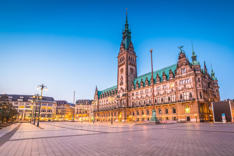 Das Rathaus in Hamburg ist in der Abenddämmerung ein atemberaubender Anblick und zeigt die architektonische Schönheit und historische Bedeutung dieses Wahrzeichens. Wenn die Sonne untergeht und einen warmen Schein über die Stadt wirft