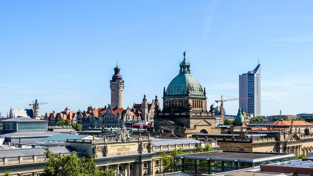 Ein Blick auf eine Stadt mit einem Uhrturm im Hintergrund, aufgenommen von einem Umzugsunternehmen in Leipzig.